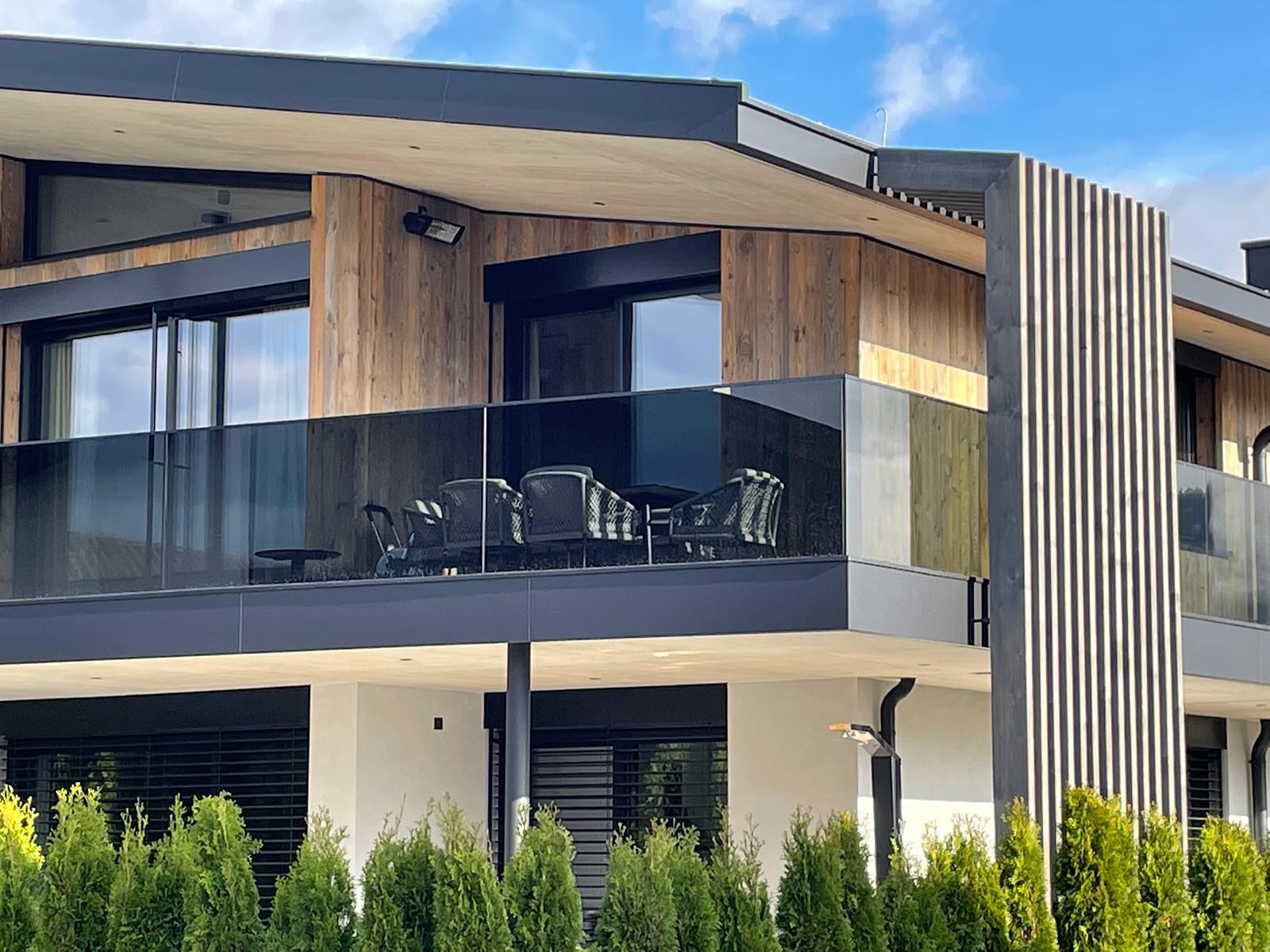 Holzfassade mit Glasbalkonen
